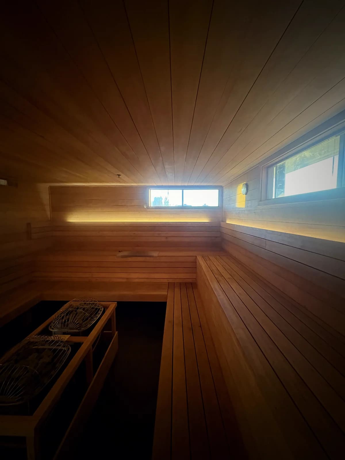 Wide view of the cedar benches and stone heaters in the sauna at Rejuuv-n in Reno