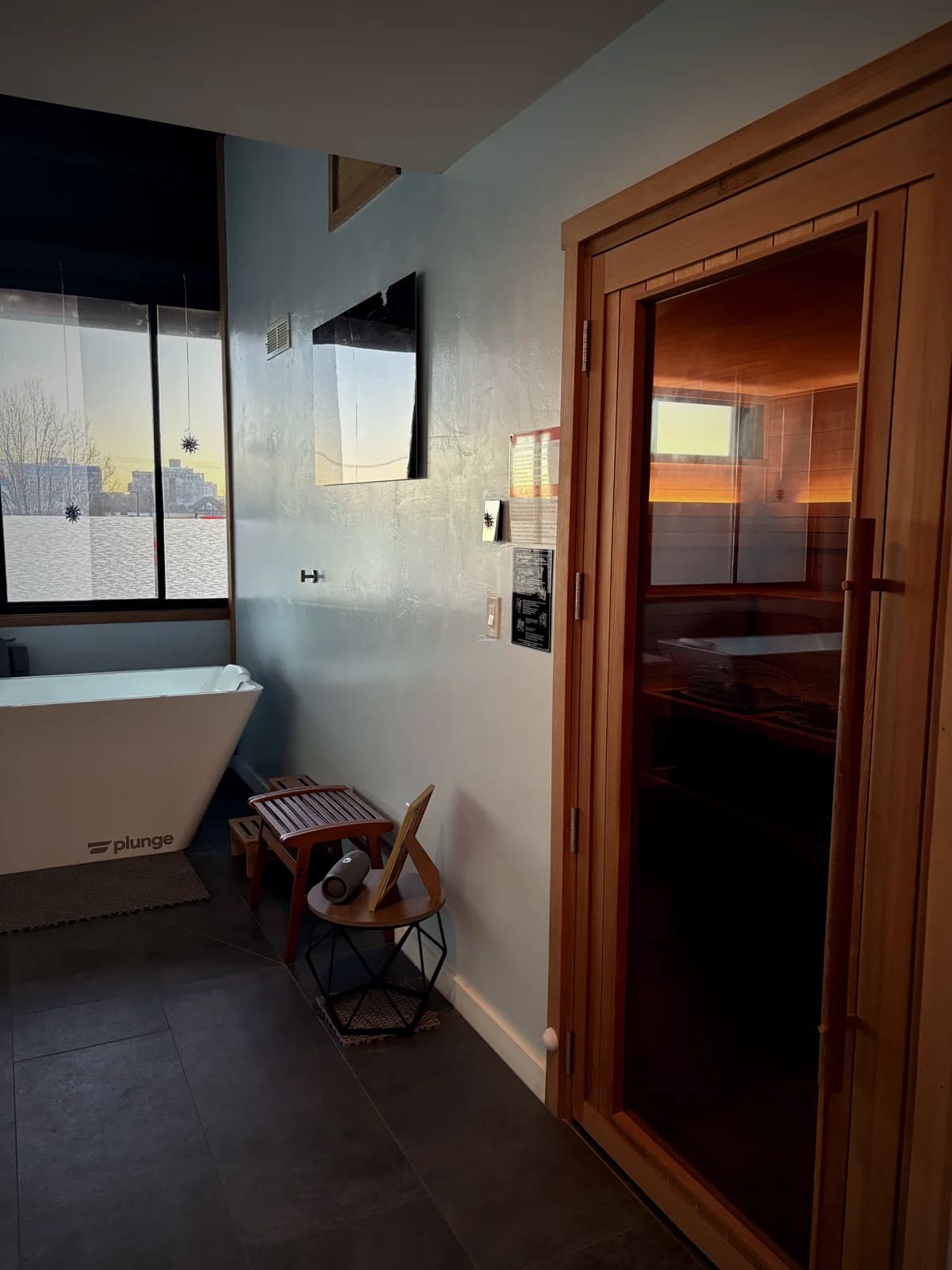 The cold plunge beside the warm-lit cedar sauna door at Rejuuv-n in Reno